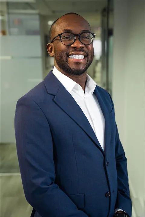 Anthony Omini, founder of Cross River Tech, in a navy blazer at his Dallas office