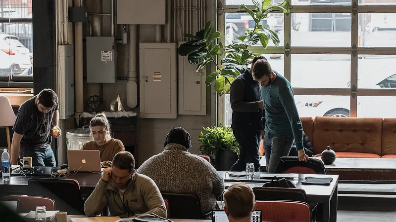 People working on laptops at long tables in a Deep Ellum coworking space