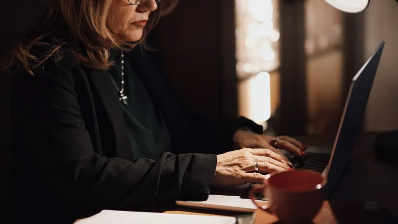 Woman working at a laptop in a warmly lit home office