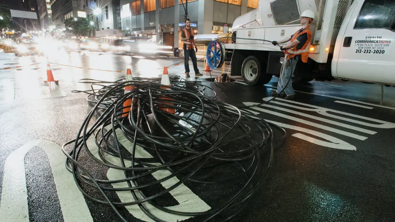 Crew installing fiber optic cable in a city street