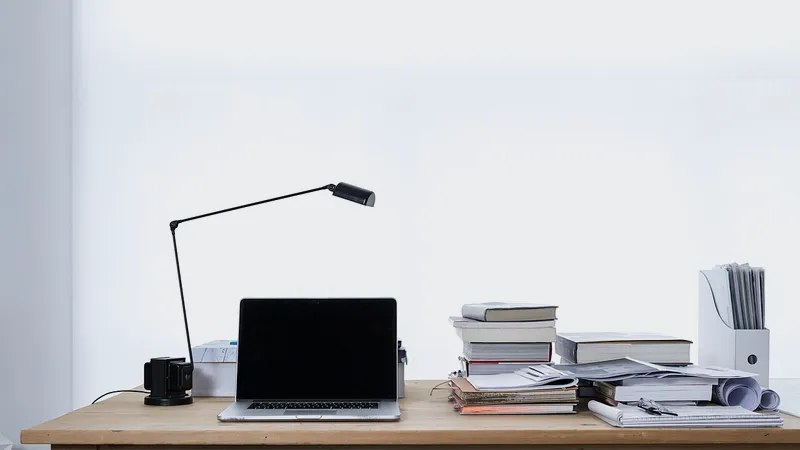 Laptop and mouse left behind on an empty office desk