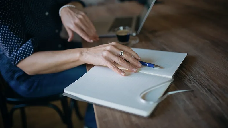 Notebook, pen and laptop on a desk while reviewing questions
