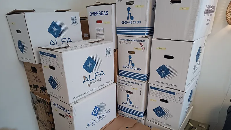 Stacked cardboard moving boxes against a wall