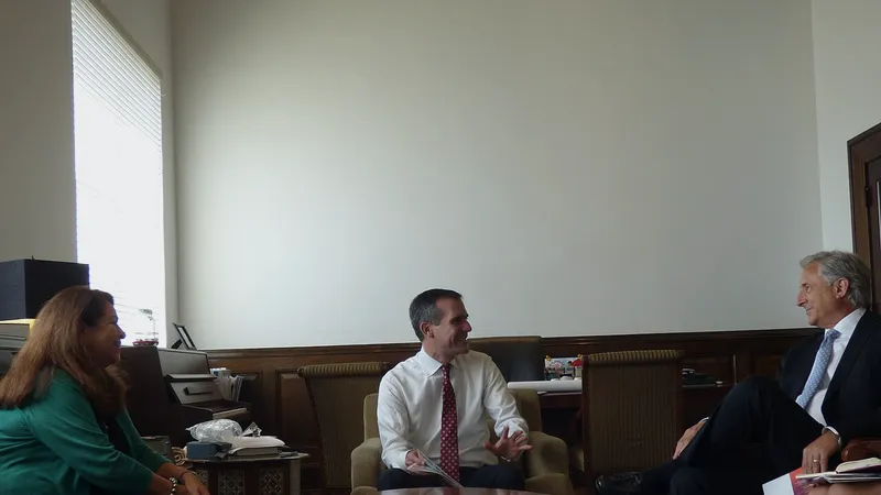 Three people talking across a low round table in a wood-panelled office
