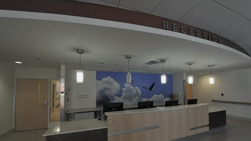 Modern clinic reception desk with a sky mural