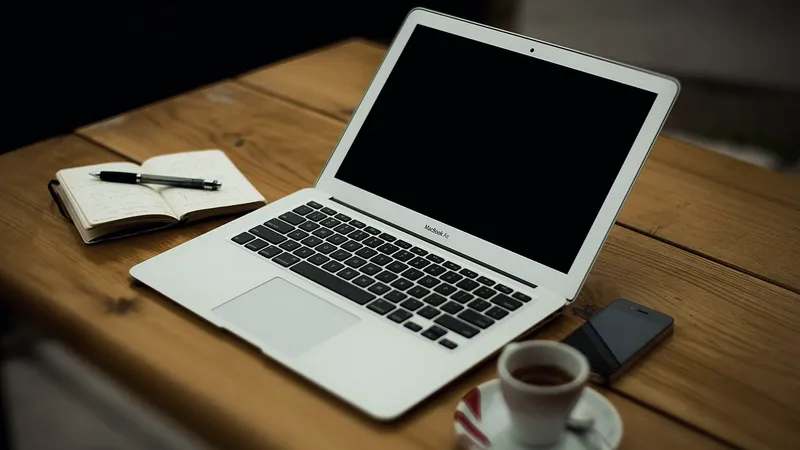 Laptop, coffee and notebook on a kitchen table