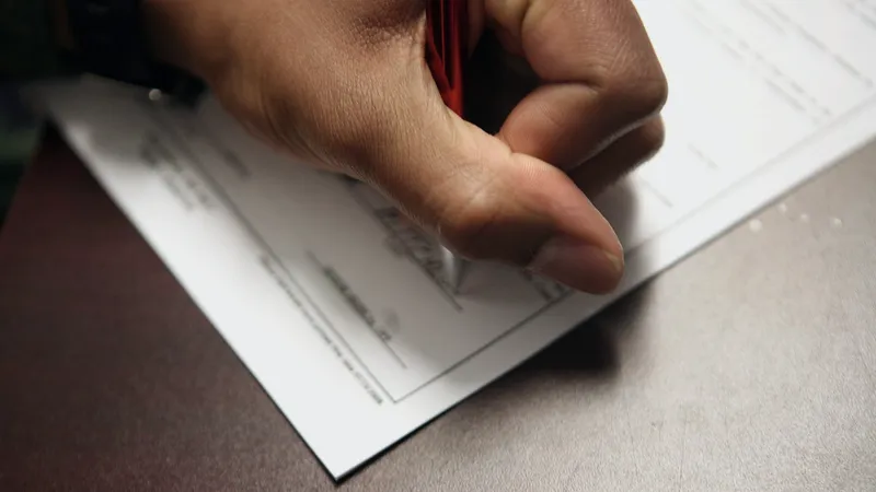 Hand holding a pen over a printed document