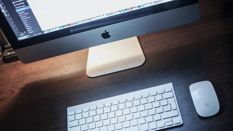 Desktop computer, keyboard and mouse on a dark wooden office desk
