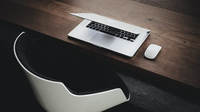 Laptop and empty chair at a tidy wooden office desk